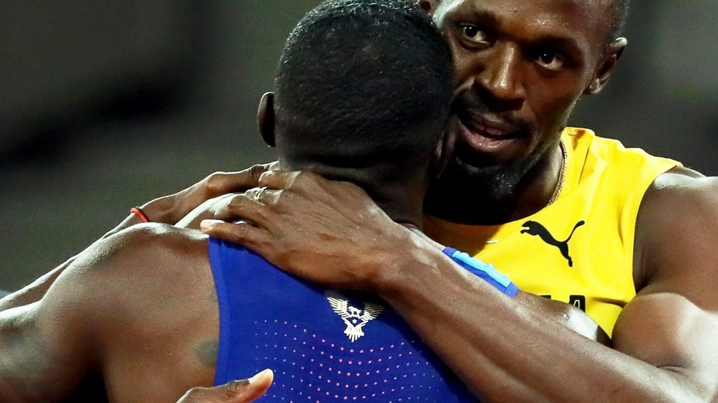 Usain Bolt abraza a Justin Gatlin, campeón mundial tras la final de los 100 metros lisos.