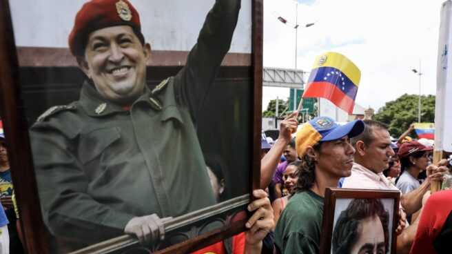 Manifestantes pro gubernamentales portan retratos de Hugo Chávez frente a la Asamblea Constituyente.