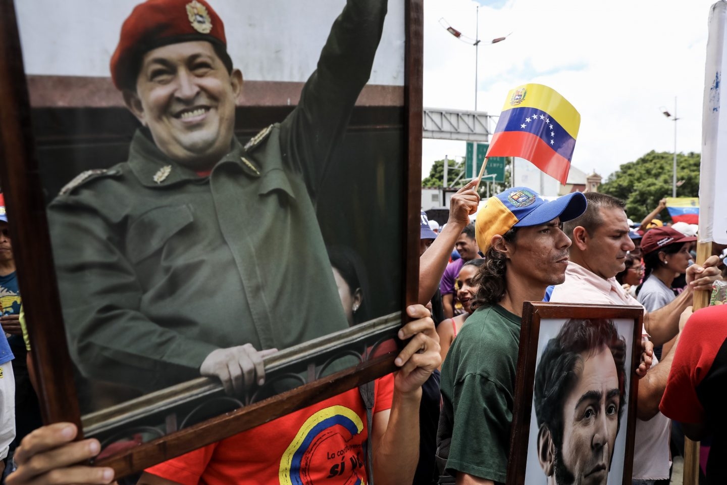 Manifestantes pro gubernamentales portan retratos de Hugo Chávez frente a la Asamblea Constituyente.