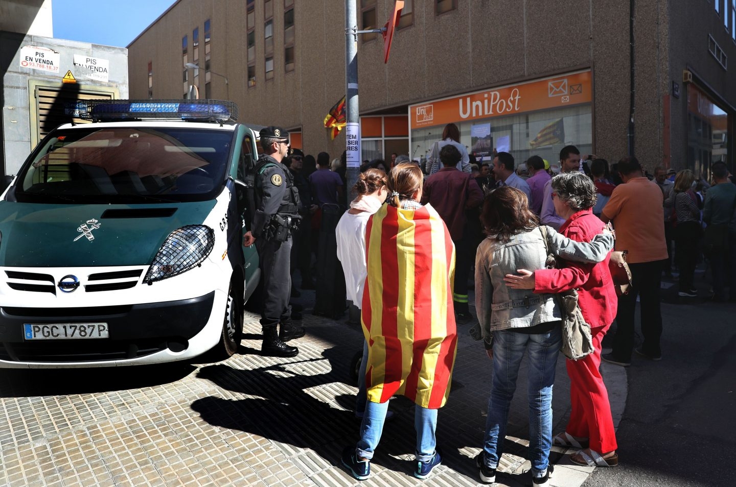 Numerosas personas permanecen ante la oficina de la empresa de mensajería Unipost en Terrassa (Barcelona), durante el registro que agentes de la Guardia Civil están efectuando en dicho local, donde se han incautado de abundante documentación relacionada con el censo del referéndum del 1-O.