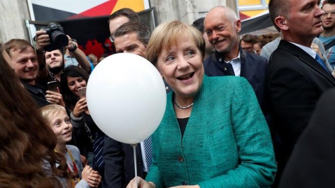 Angela Merkel recibe un globo de un niño en la campaña electoral en Berlín.