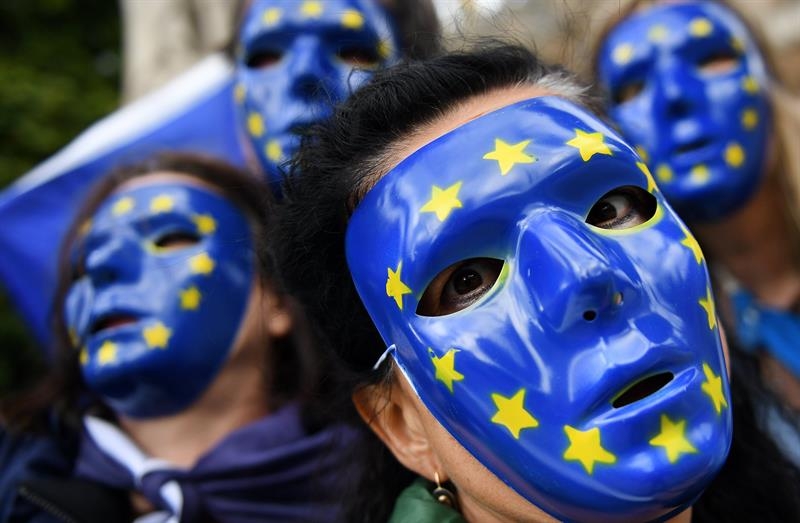Jóvenes con caretas de la Unión Europea en una manifestación.