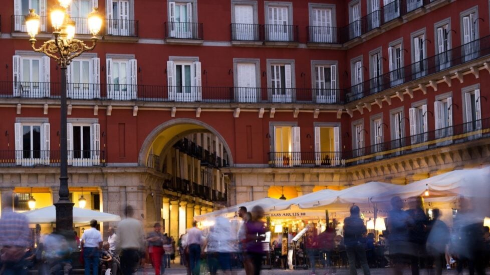 Transeúntes en la plaza al atardecer.