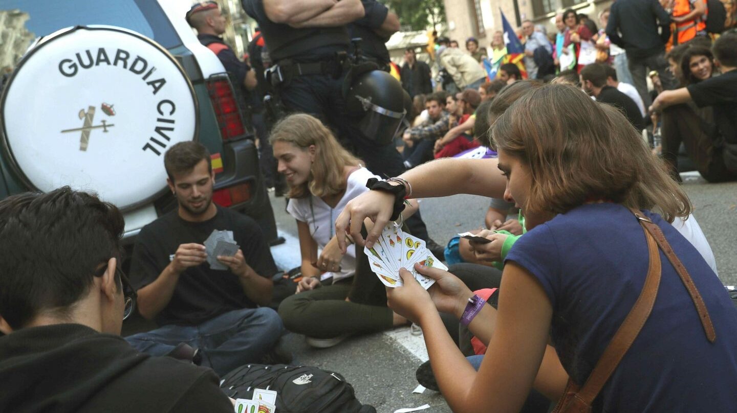Un grupo de manifestantes, jugando a las cartas junto a un coche de la Guardia Civil.