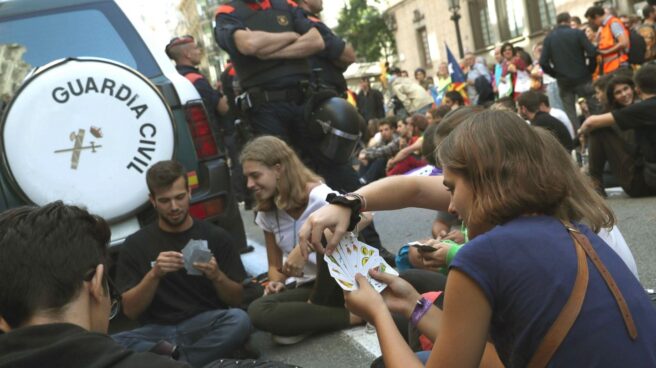 Un grupo de manifestantes, jugando a las cartas junto a un coche de la Guardia Civil.