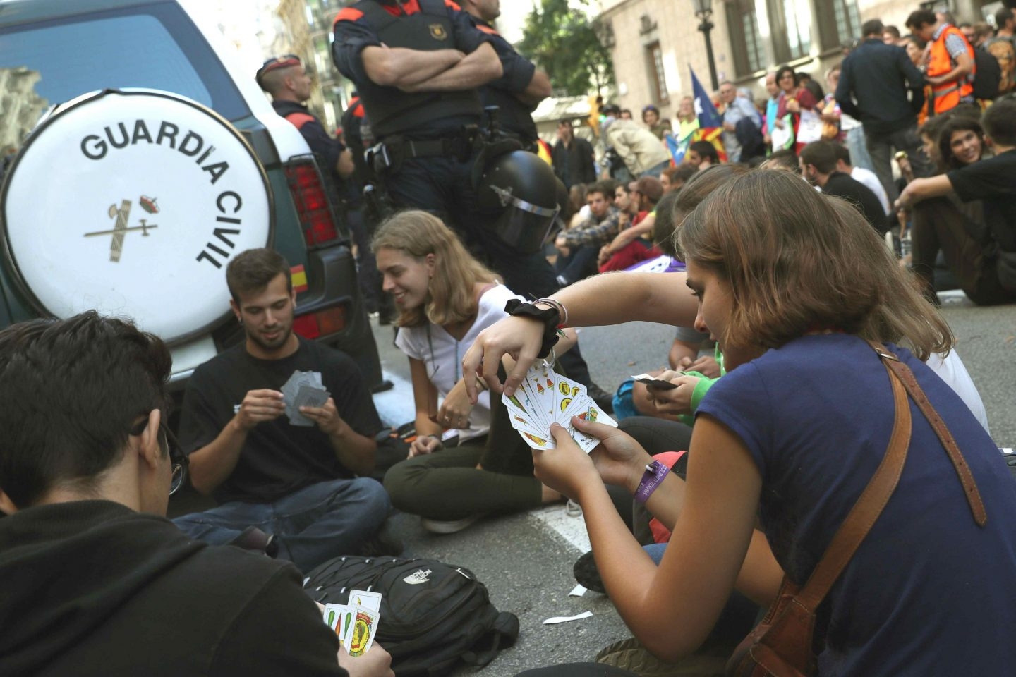 Un grupo de manifestantes, jugando a las cartas junto a un coche de la Guardia Civil.