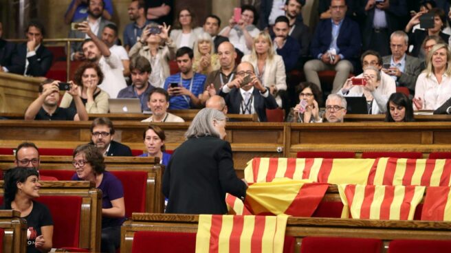 La diputada de Podem Ángels Martínez reitra las banderas de España del hemiciclo del Parlament y deja las esteladas catalanas.