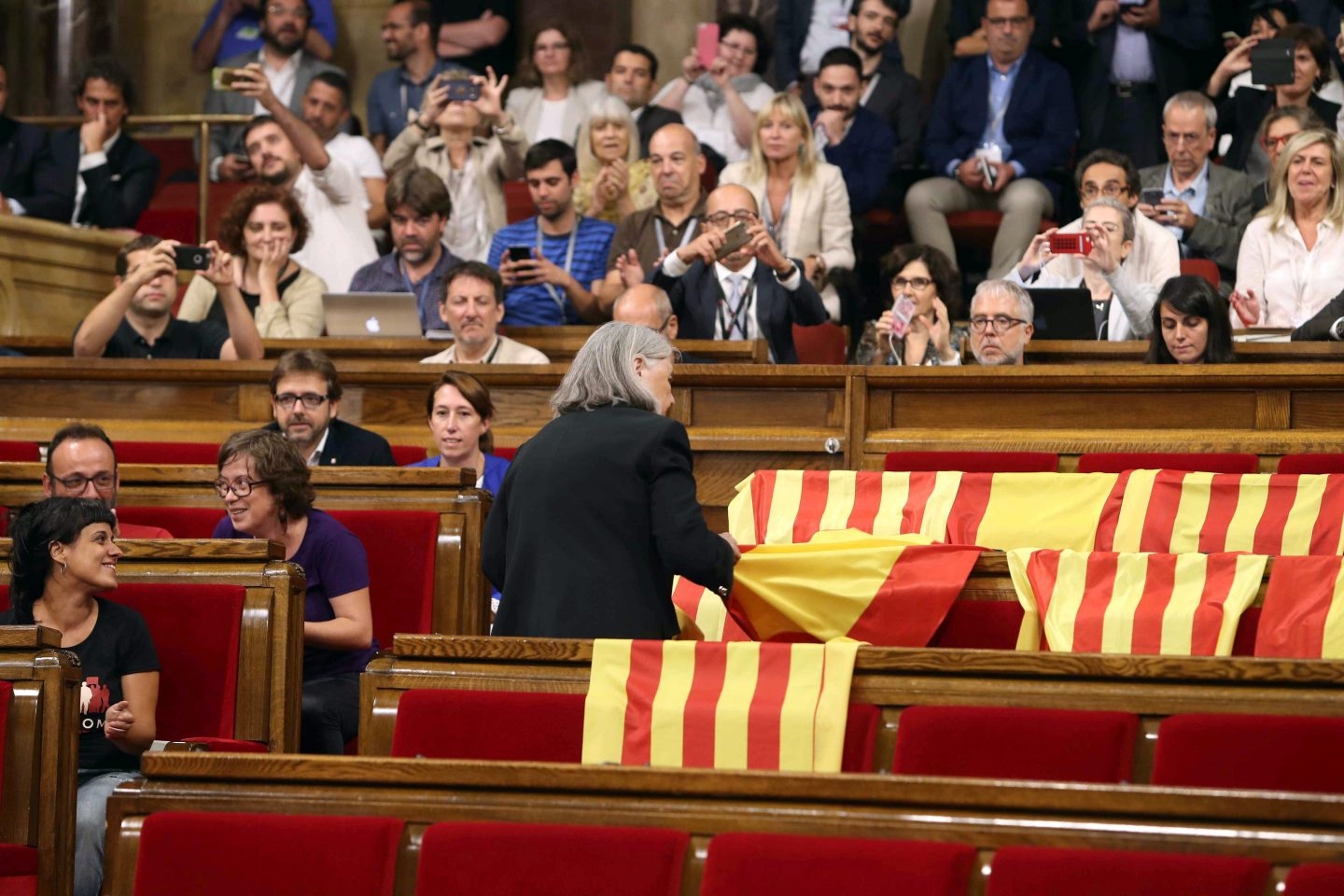 La diputada de Podem Ángels Martínez reitra las banderas de España del hemiciclo del Parlament y deja las esteladas catalanas.