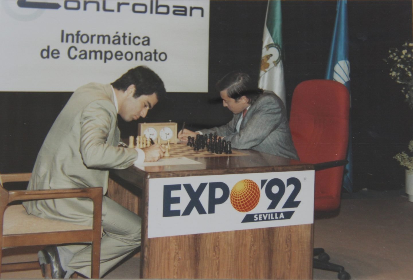 Kasparov y Karpov (sentado en una silla roja), en el desarrollo de una de las partidas.