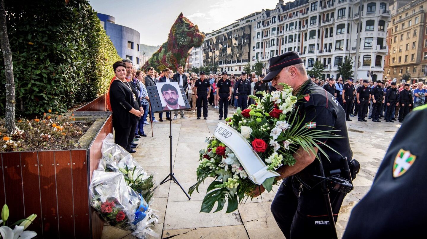 Agentes de la Ertzaintza ponen flores delante del monolito que hay en recuerdo de Txema Agirre.