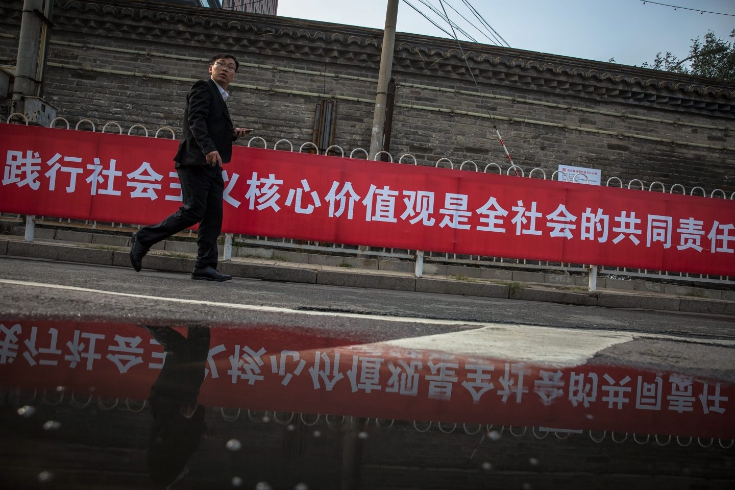 Un hombre pasa junto a una pancarta con propaganda del XIX Congreso del .Comunista de China