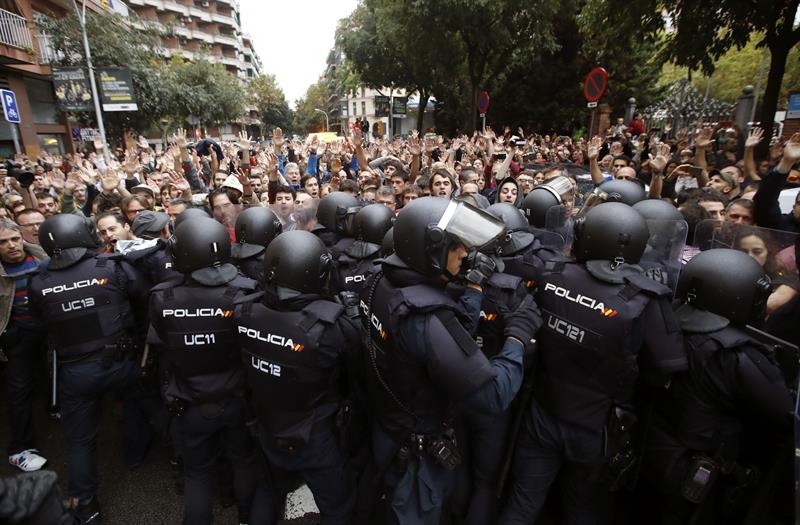 Antidisturbios de la Policía Nacional forman un cordón de seguridad en los alrededores de un colegio electoral de Barcelona el pasado 1-O.