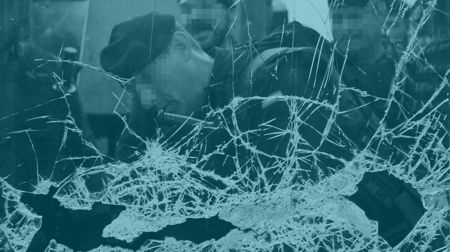 Un guardia Civil tras un cristal roto en un centro de votación.