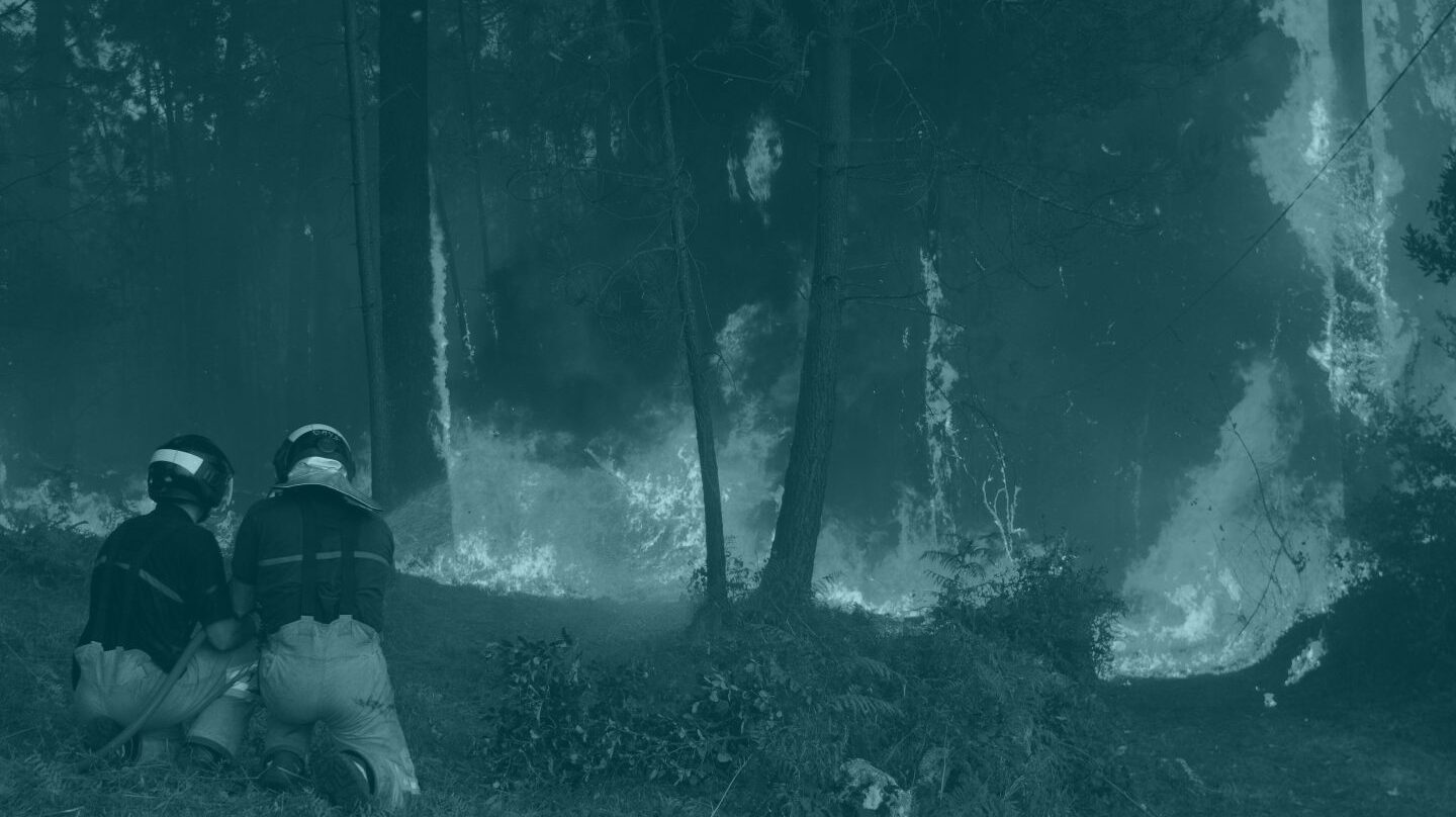 Dos brigadistas se enfrentan a uno de los incendios en Galicia.