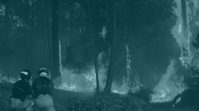 Dos brigadistas se enfrentan a uno de los incendios en Galicia.