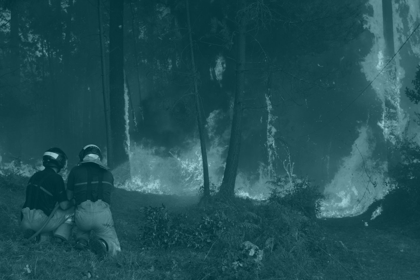 Dos brigadistas se enfrentan a uno de los incendios en Galicia.