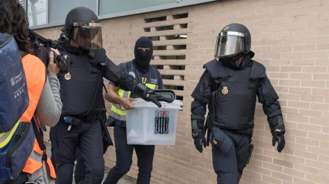Malestar de los policías nacionales con los Mossos Agentes de la Policía Nacional intervienen una urna este domingo en un centro electoral de Lleida.