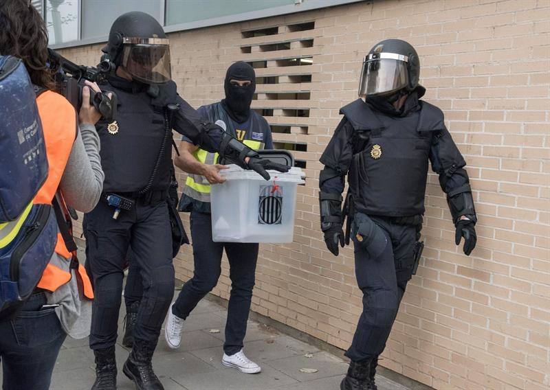 Agentes de la Policía Nacional intervienen una urna este domingo en un centro electoral de Lleida.