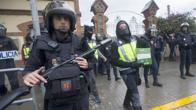 Un antidisturbios de la Policía Nacional, a las puertas de un instituto de L'Hospitalet (Barcelona) este domingo.