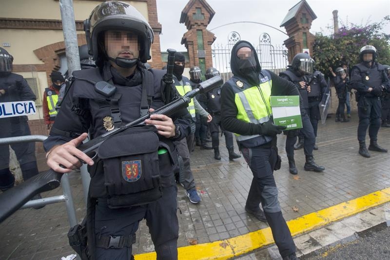 Un antidisturbios de la Policía Nacional, a las puertas de un instituto de L'Hospitalet (Barcelona) este domingo.