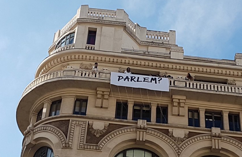 Cartel colgado llamando al diálogo en el balcón de la agencia Sra. Rushmore.