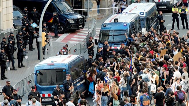 Los Mossos protegen de los manifestantes a un contingente de la Policía Nacional, en Barcelona.