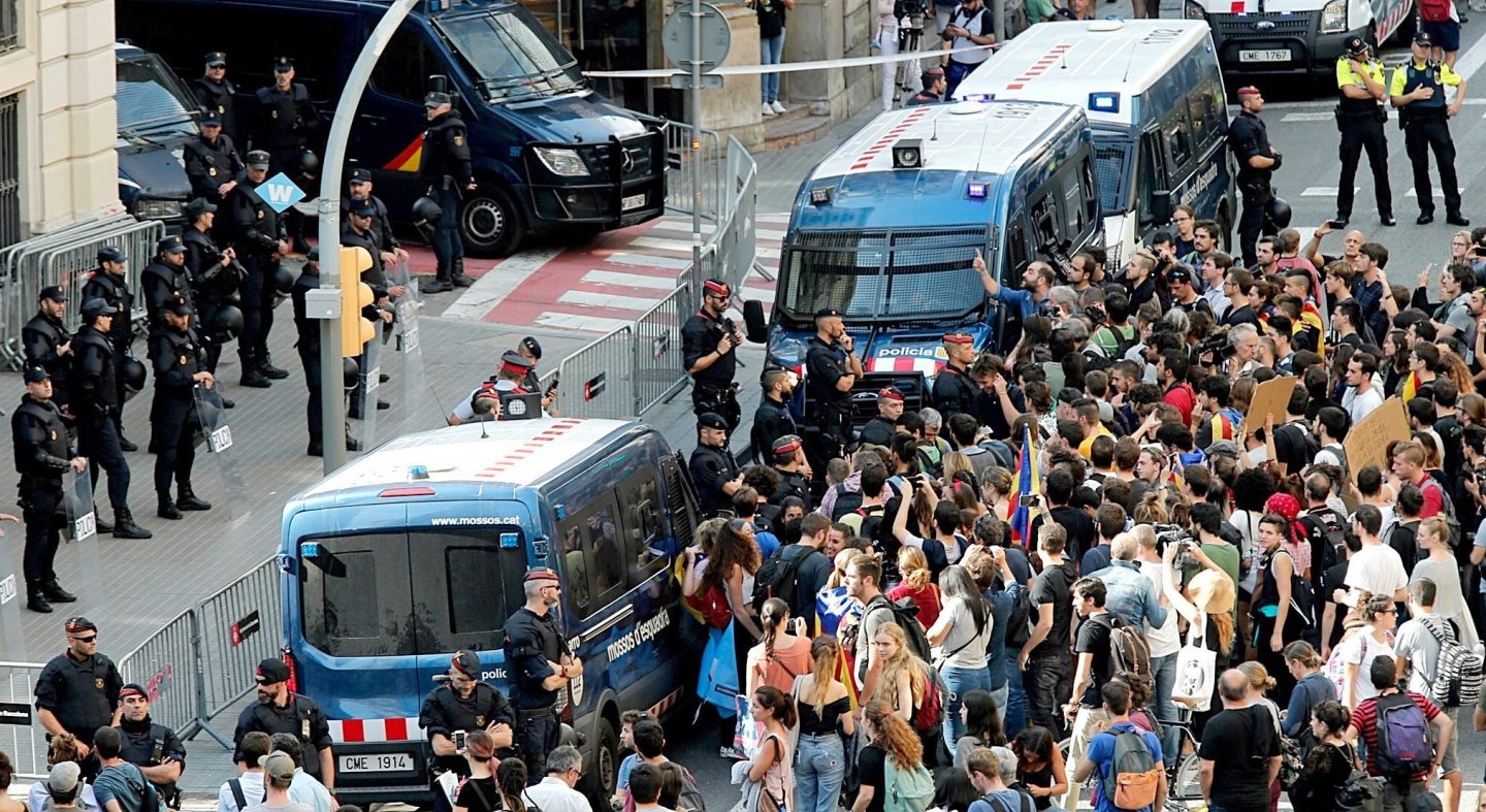 Los Mossos protegen de los manifestantes a un contingente de la Policía Nacional, en Barcelona.