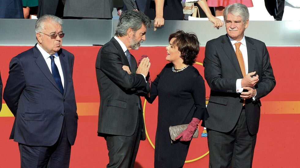 La vicepresidenta del Gobierno, Soraya Sáenz de Santamaría (2d), conversa con el presidente del Tribunal Supremo (TS) y del Consejo General del Poder Judicial (CGPJ), Carlos Lesmes (2i), en presencia del presidente del Tribunal Constitucional, Juan José González Rivas (i), y el ministro de Asuntos Exteriores, Alfonso Dastis (d), durante el desfile del Día de la Fiesta Nacional.