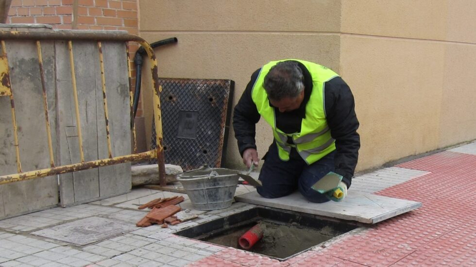Un hombre trabaja en la reparación de una acera.