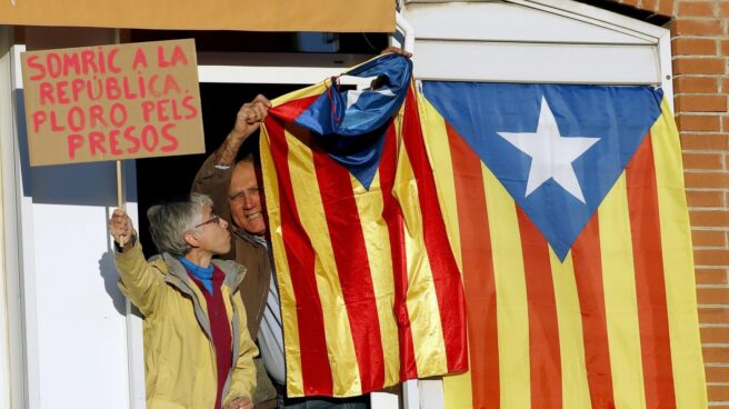 Un vecino saca una bandera "estelada" por la ventana durante la manifestación convocada en Barcelona por la ANC y Ómnium Cultural.