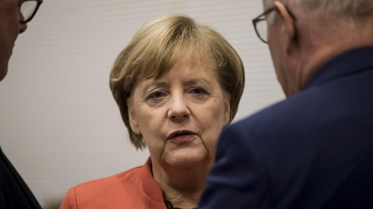 La cancilller Angela Merkel conversa con sus colaboraderes, en Berlín.
