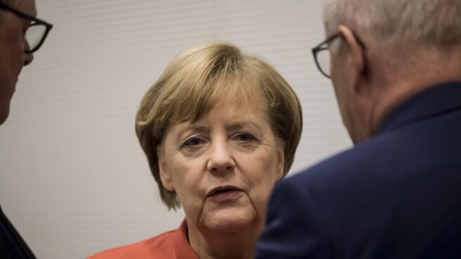 La cancilller Angela Merkel conversa con sus colaboraderes, en Berlín.