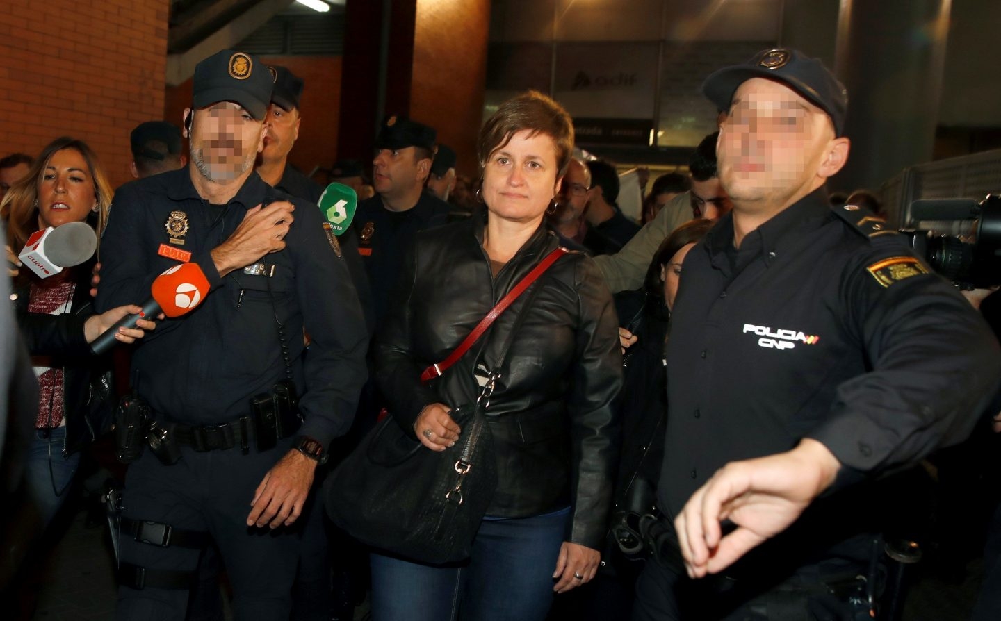 Anna Simó es protegida por la Policía a su llegada a Madrid.