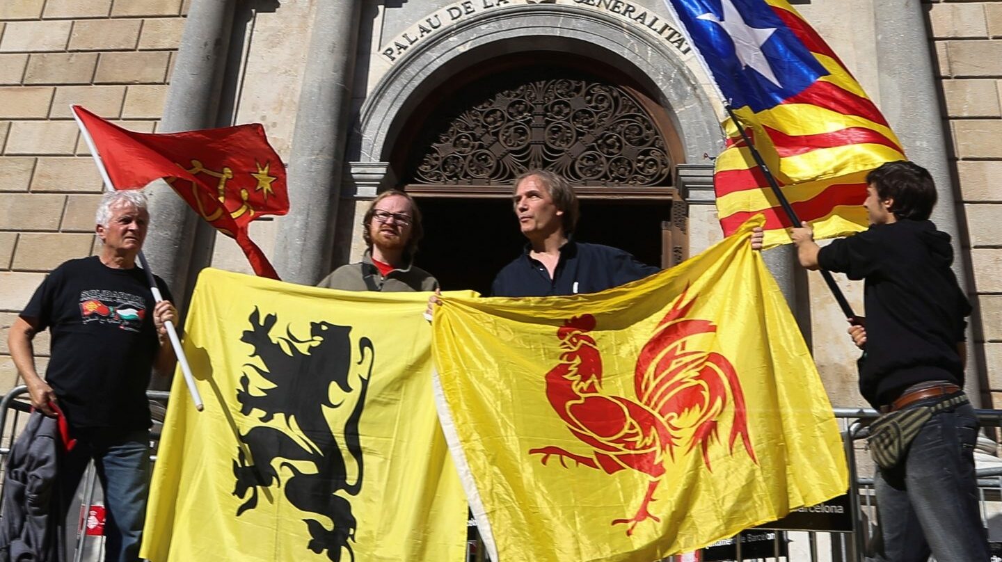 Banderas (de izda a dcha) de las regiones de Occitania, Flandes, Valonia y la estelada, frente al Palau de la Generalitat.
