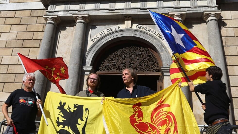 Banderas (de izda a dcha) de las regiones de Occitania, Flandes, Valonia y la estelada, frente al Palau de la Generalitat.