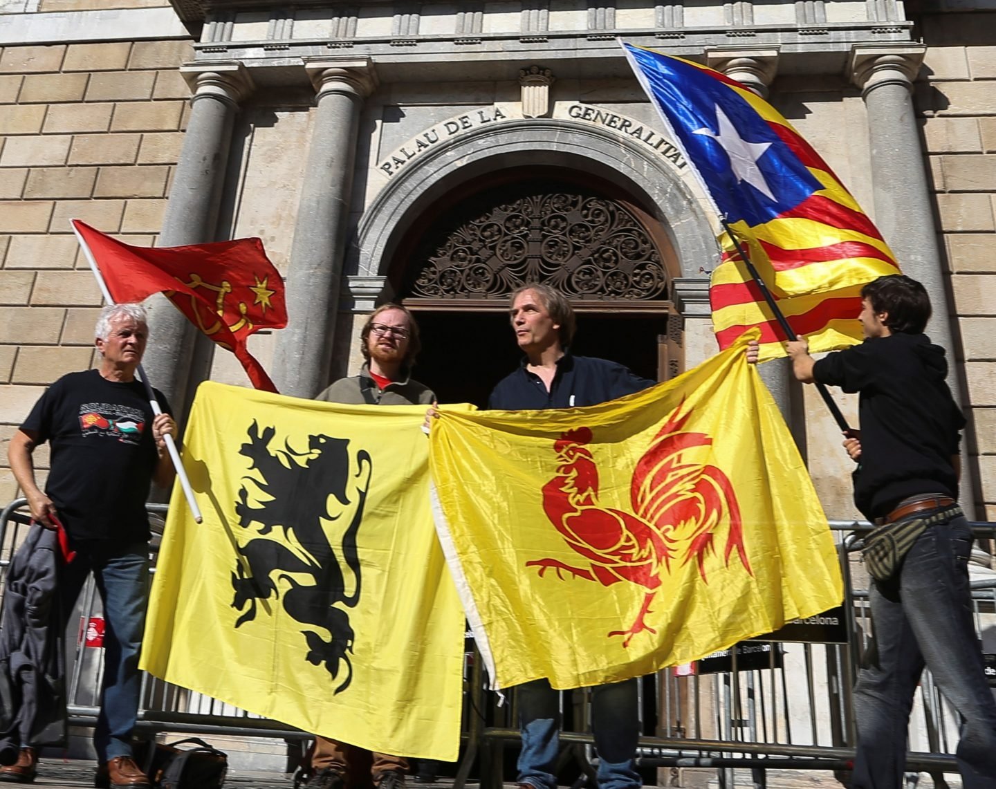 Banderas (de izda a dcha) de las regiones de Occitania, Flandes, Valonia y la estelada, frente al Palau de la Generalitat.