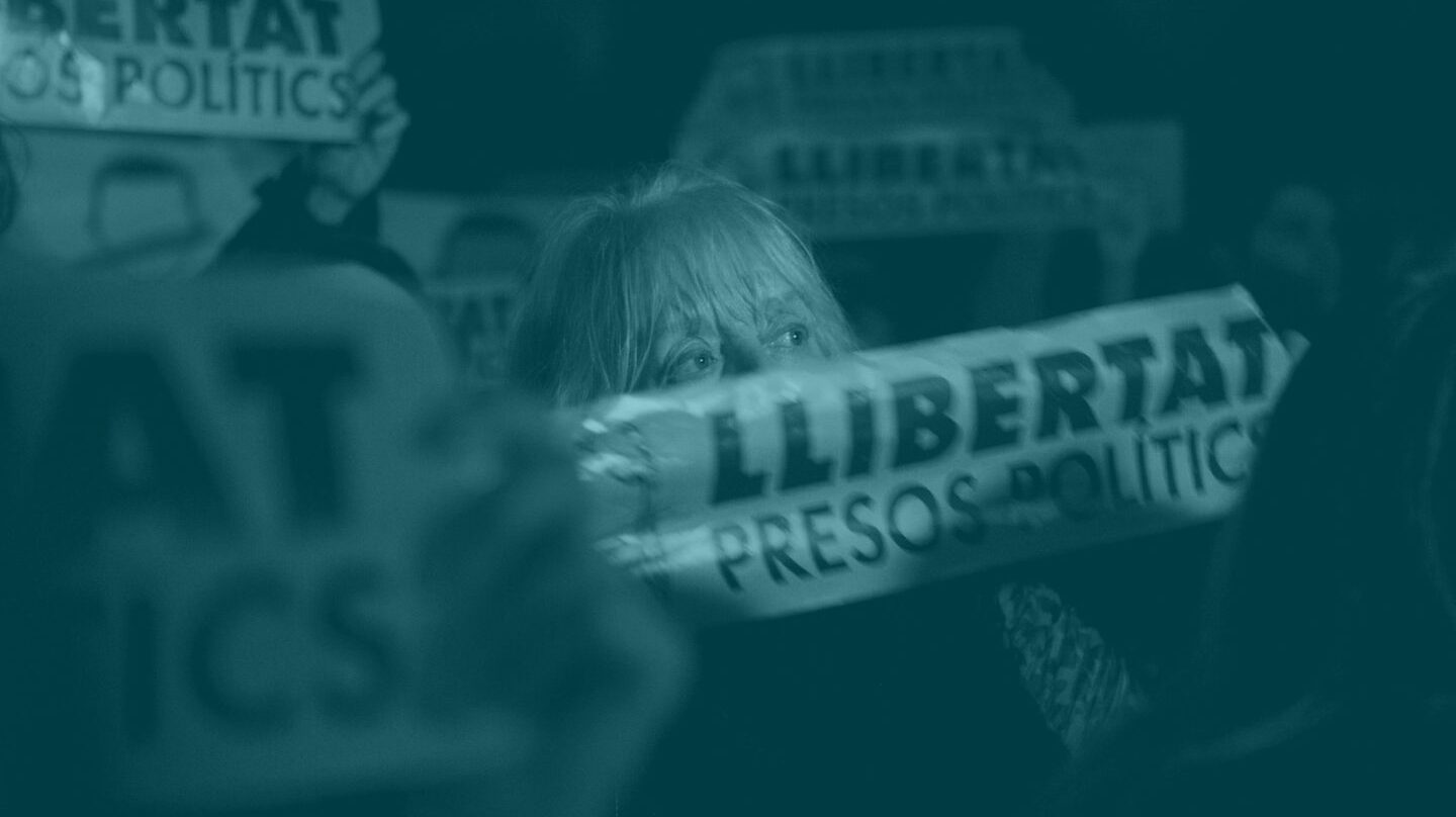 Una mujer muestra una pancarta con la palabra 'Libertad'.