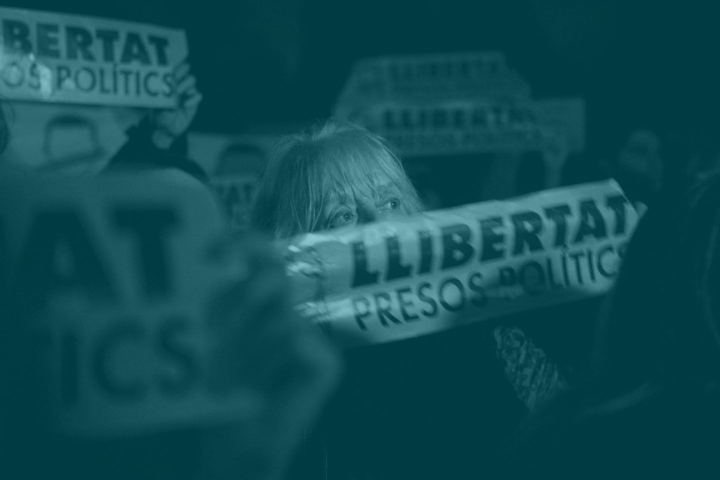 Una mujer muestra una pancarta con la palabra 'Libertad'.