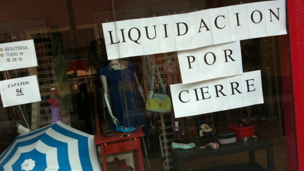 Pequeño comercio cuelga el cartel de liquidación por cierre.