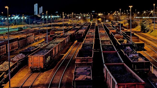 Estación ferroviaria de noche, con trenes de mercancías.