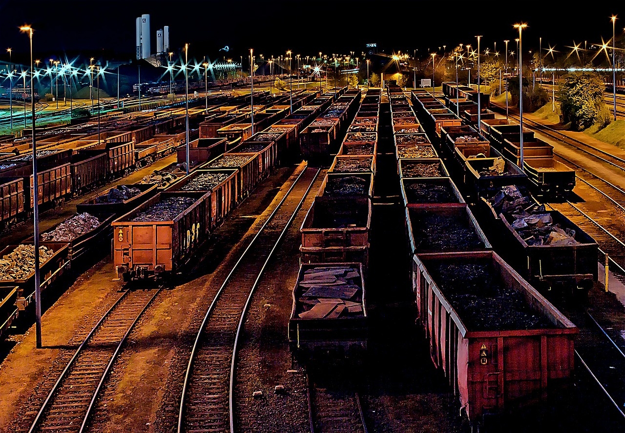 Estación ferroviaria de noche, con trenes de mercancías.