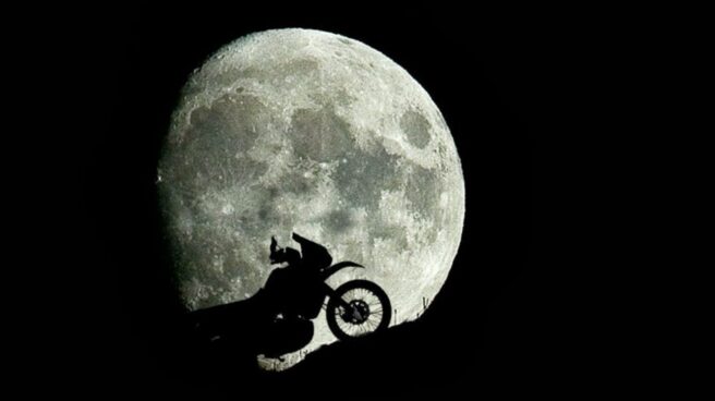 Una moto frente a la luna casi llena Una moto frente a la luna casi llena