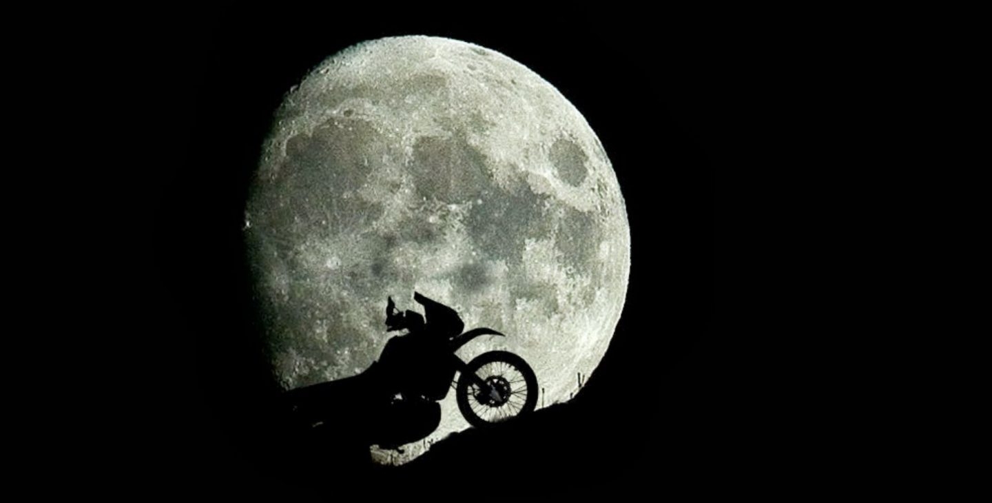 Una moto frente a la luna casi llena