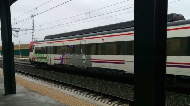 Un tren de Renfe de Cercanías circula pintado de grafitis.