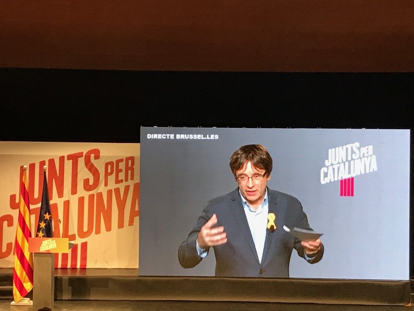 Puigdemont interviene por videoconferencia en un mítin de Junts per Catalunya.