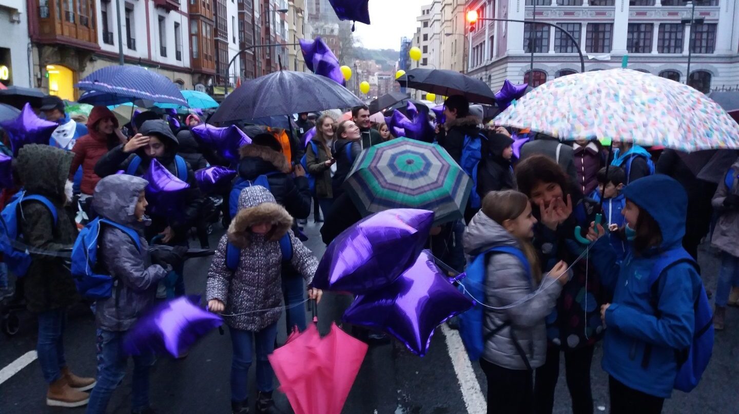 En la cabecera de la manifestación un grupo de niños, con mochila y globos lila, conversa minutos antes del inicio de la marcha.