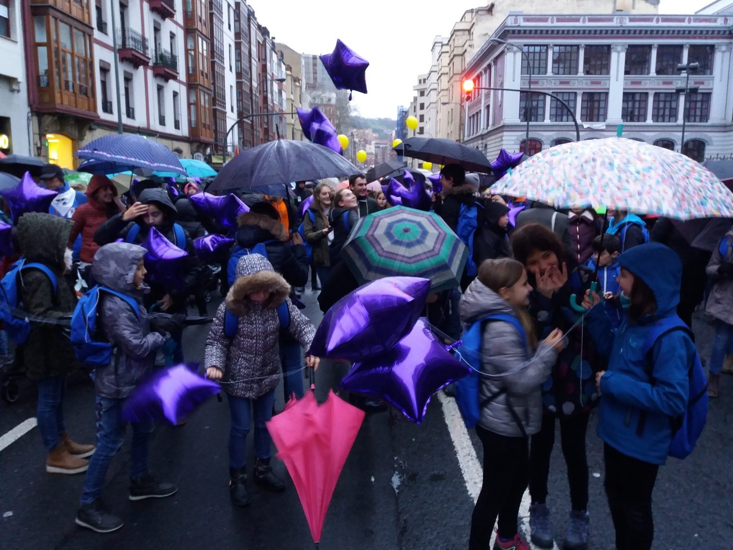 En la cabecera de la manifestación un grupo de niños, con mochila y globos lila, conversa minutos antes del inicio de la marcha.