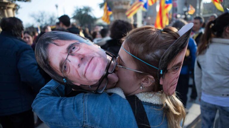 Una manifestante besa una careta de Puigdemont.