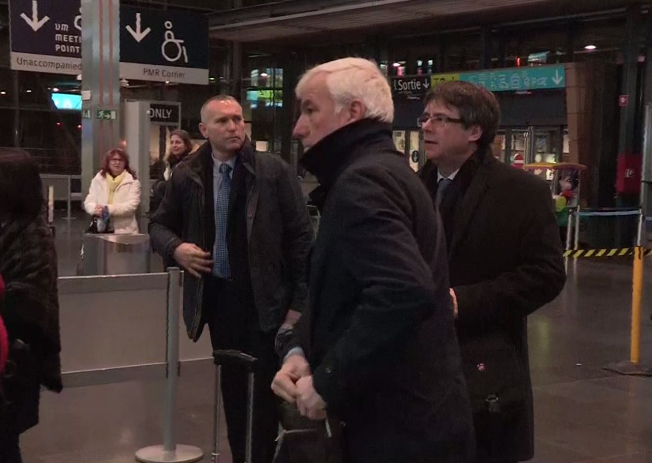 Luis Escola (al fondo), junto a Carles Puigdemont y el empresario Matamala, a punto de embarcar en dirección a Copenhague (Dinamarca).
