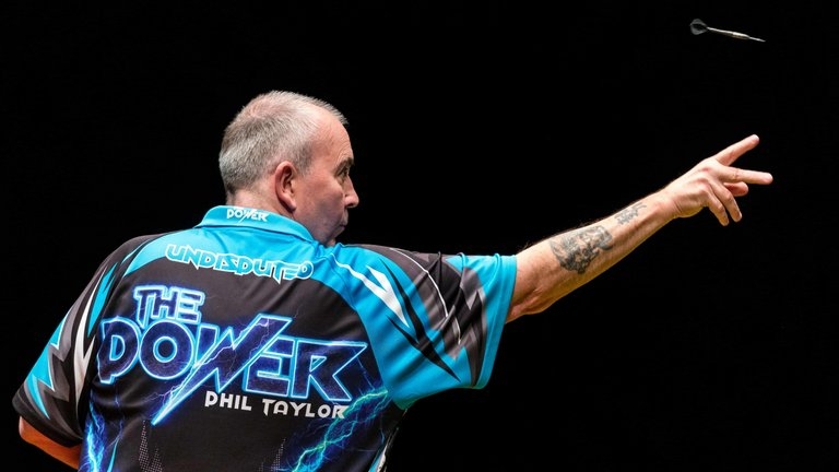 Phil Taylor lanzando dardos.